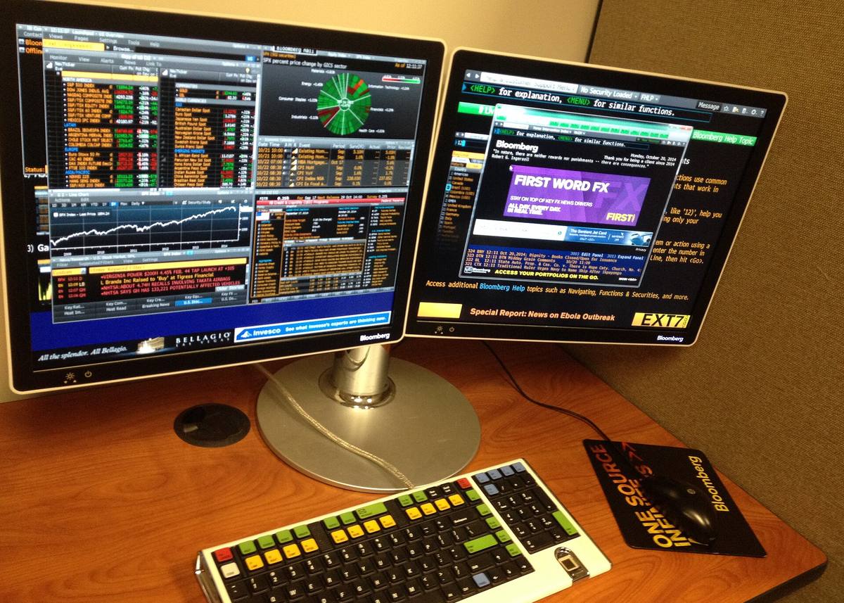 A Bloomberg terminal keyboard and monitor arranged on an analyst's desk.